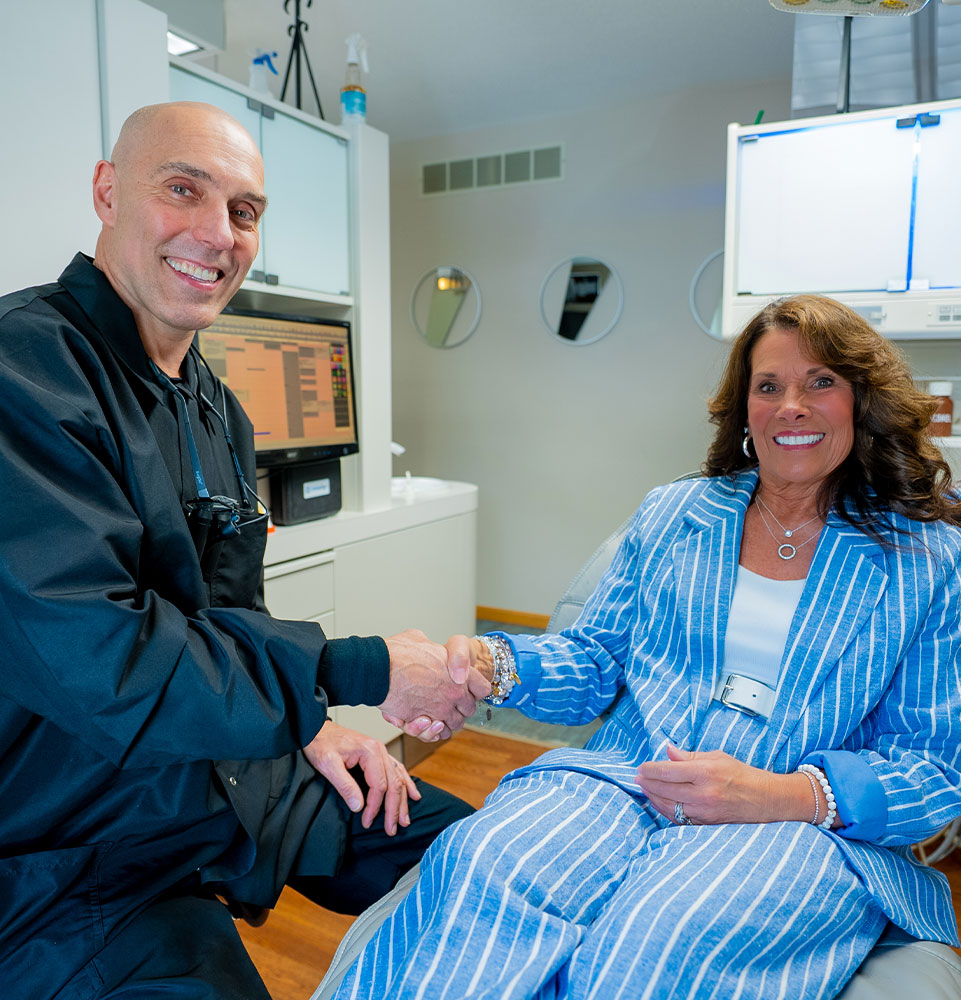 dr flack with patient smiling shaking hands