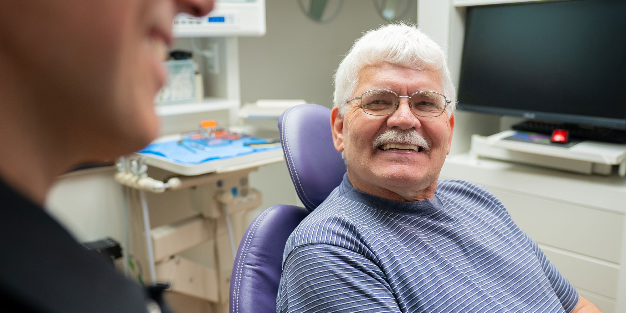 male patient striped shirt smiling