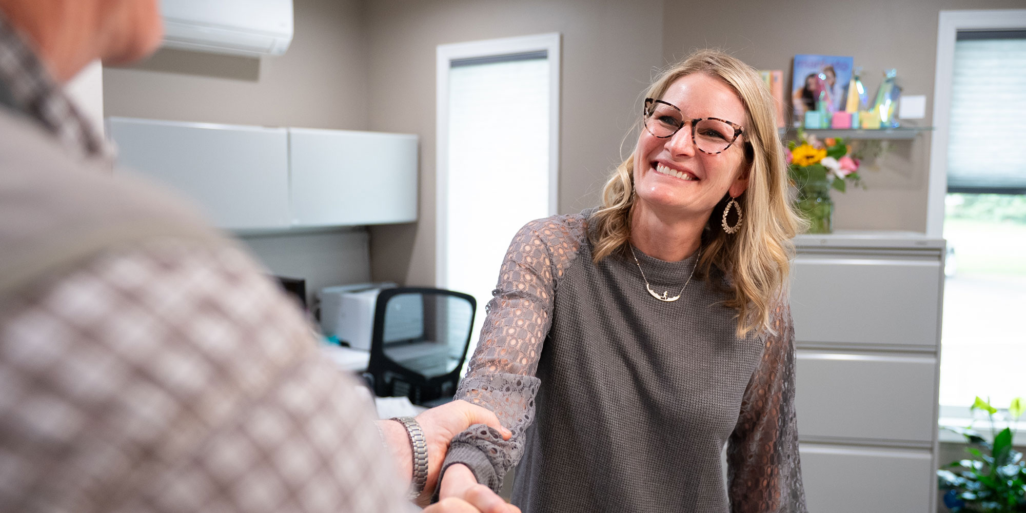 team with necklace welcoming patient